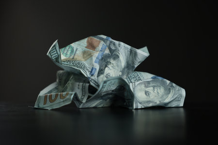 Burning dollar banknotes on black table against dark backgroundの写真素材