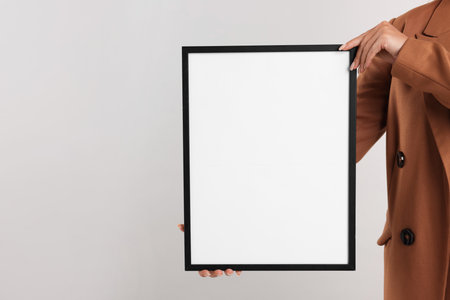 Woman with diploma blank frame on light background, closeup. Mockup for designの写真素材