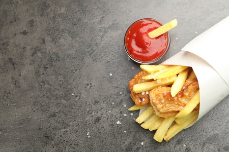 British Traditional Fish and chips with sauce on gray table, flat lay. Space for text