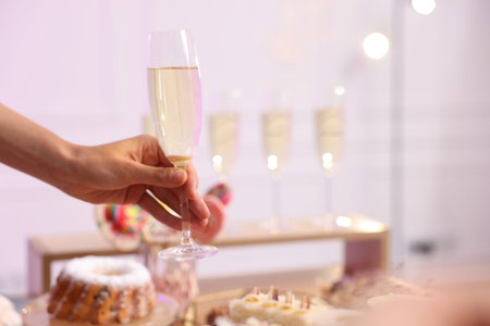 Guest taking glass of sparkling wine from buffet table, closeup. Space for text