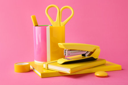 Stapler and other stationery on pink backgroundの写真素材