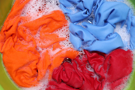 Clothes, water and foam in plastic basin, top viewの写真素材