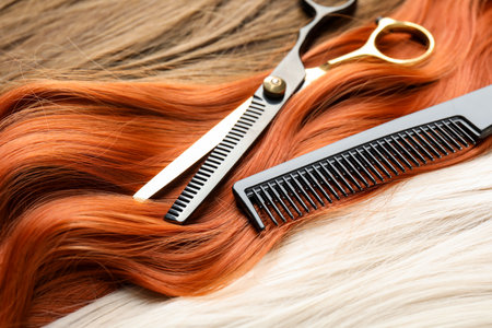 Scissors and comb on beautiful hair in different colors, closeupの写真素材