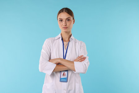 Professional nurse with badge on light blue backgroundの写真素材