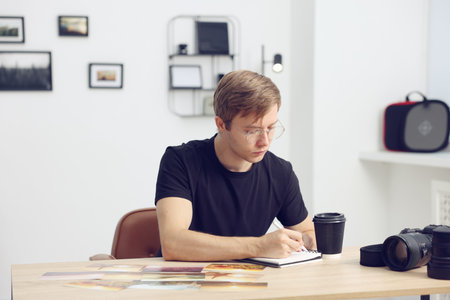 Professional photographer working at wooden table in studioの写真素材