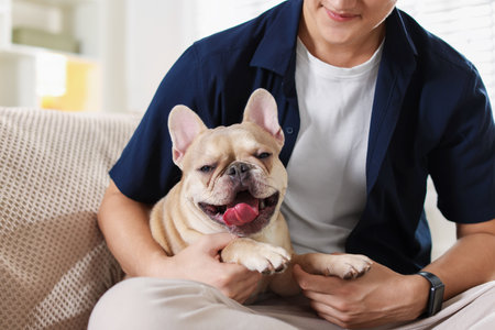 Man with his cute French bulldog at home, closeupの写真素材