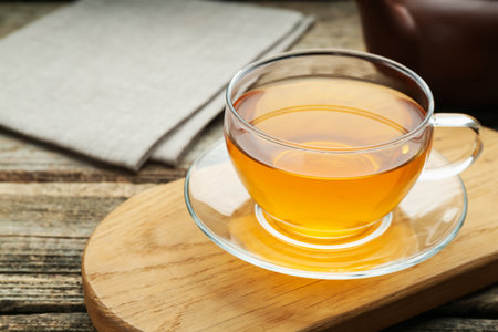 Aromatic black tea in glass cup on wooden table, closeup. Space for textの写真素材