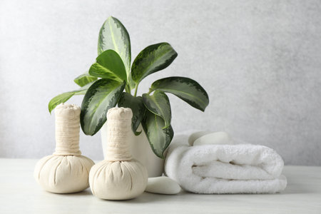 Beautiful spa composition with herbal bags on table against light gray backgroundの写真素材