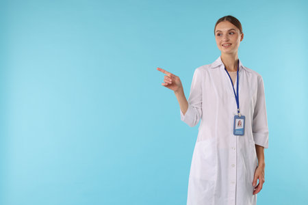 Professional nurse with badge on light blue background, space for textの写真素材