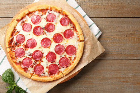 Pepperoni pizza with fresh basil on wooden table, top view. Space for textの写真素材
