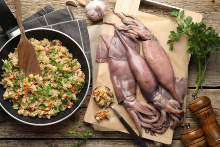 Raw squids, stuffing and parsley on wooden table, flat lay