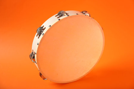 Tambourine on orange background. Traditional musical instrumentの写真素材