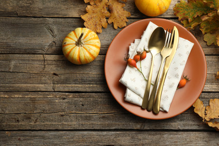 Beautiful table setting with autumn decor on wooden background, flat lay. Space for textの写真素材