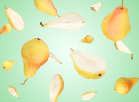 Many fresh pears falling on turquoise background