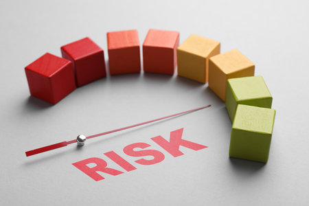 Arrow indicating level of risk on scale made of colorful cubes on gray backgroundの写真素材