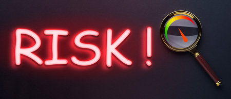 Word Risk and magnifying glass with scale inside on black background, top view
