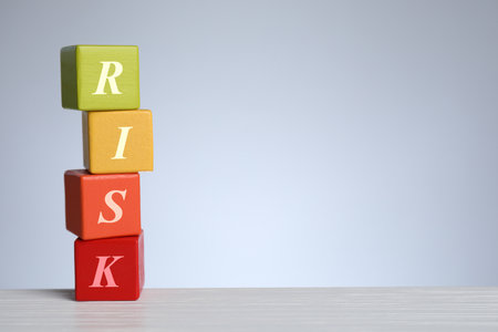 Risk word make of wooden cubes on table against gray backgroundの写真素材