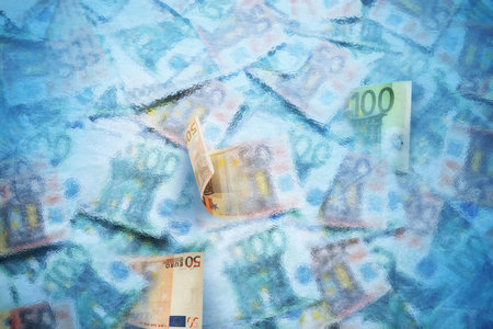 Money frozen. Many euro bills under iceの写真素材