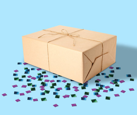 Holiday delivery. Box and confetti on light blue backgroundの写真素材