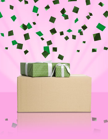 Holiday delivery. Parcel and gift boxes under falling confetti on pink gradient backgroundの写真素材