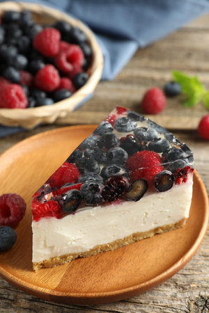 Piece of delicious cheesecake with berries on wooden table, closeupの写真素材