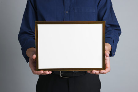 Man with diploma blank frame on light gray background, closeup. Mockup for designの写真素材