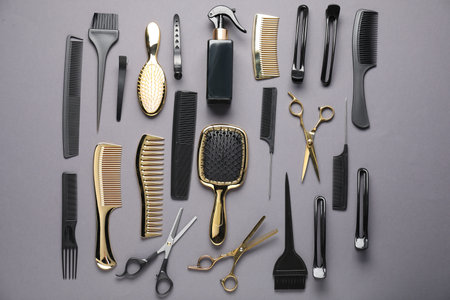 Different hair styling tools on gray background, flat lay