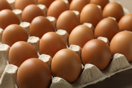 Many raw chicken eggs in carton on table, closeupの写真素材