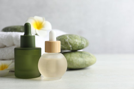 Beautiful spa composition with essential oils on light table, closeup. Space for textの写真素材