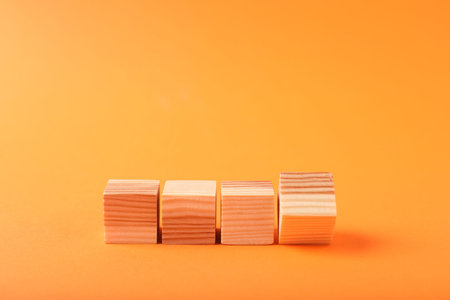 Blank wooden cubes on orange background, space for text