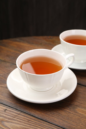 Aromatic black tea in cups on wooden table, closeupの写真素材