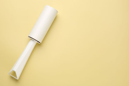One lint roller on yellow background, top view. Space for textの写真素材