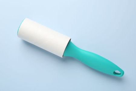 One lint roller on light blue background, top viewの写真素材