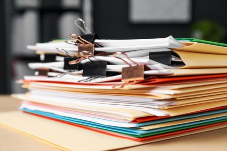 Many folders with documents and binder clips on wooden desk, closeupの写真素材