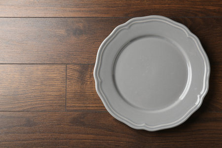 Empty ceramic plate on wooden table, top view. Space for textの写真素材