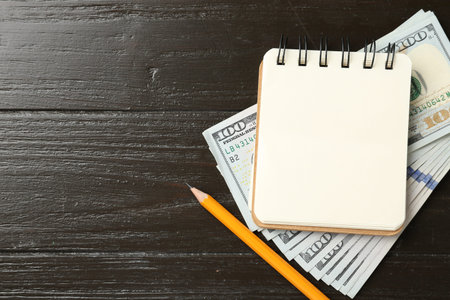 Alimony. Notebook, money and pencil on wooden table, flat lay. Space for text