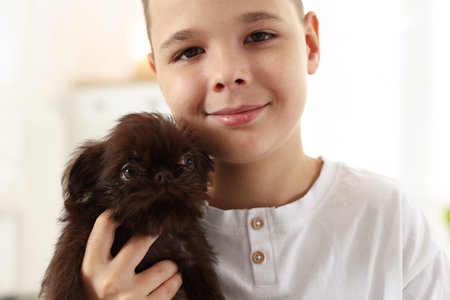 Child with cute puppy at home, closeup. Domestic petの写真素材