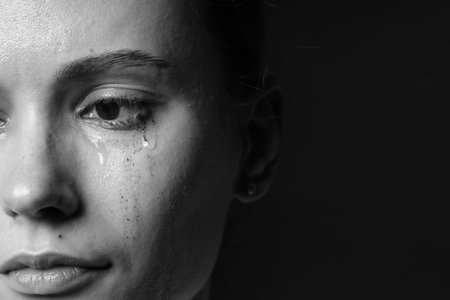 Sad woman crying on dark background, closeup. Black and white effectの写真素材