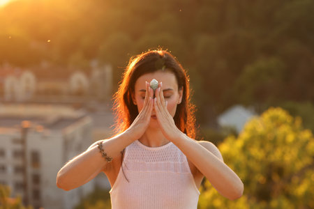 Woman meditating with crystal to heal or restore her aura outdoorsの写真素材