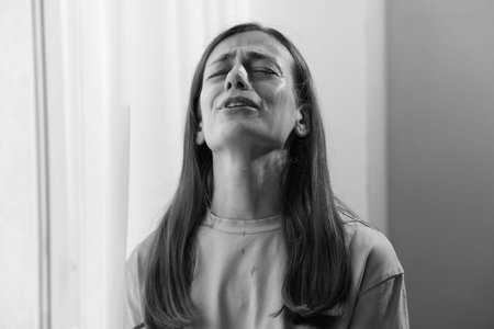 Woman crying at home. Black and white effect