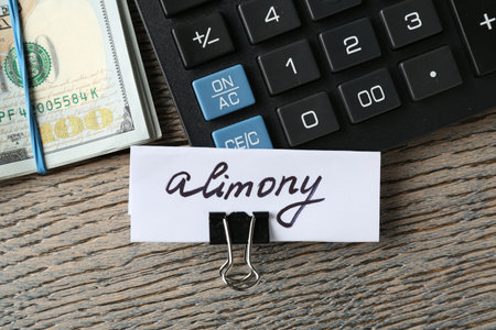 Note with word Alimony, money and calculator on wooden table, flat layの写真素材