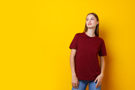 Woman wearing stylish burgundy t-shirt on yellow background. Space for textの写真素材