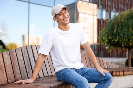 Young man wearing blank white t-shirt outdoors. Mockup for designの写真素材