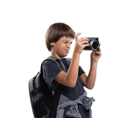 Choice of profession. Little boy with camera and backpack pretending to be a photographer on white backgroundの写真素材