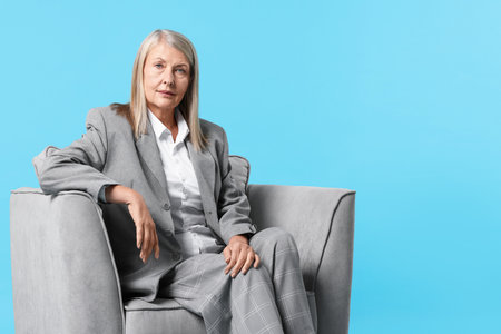 Professional psychotherapist in armchair on light blue background, space for textの写真素材