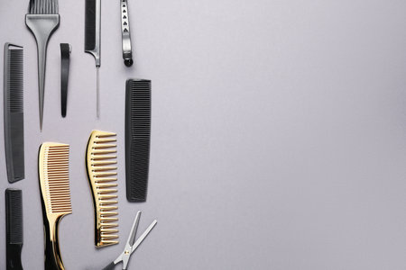 Different hair styling tools on grey background, flat lay. Space for textの写真素材