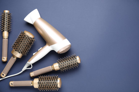 Different hair styling tools on dark blue background, flat lay. Space for textの写真素材