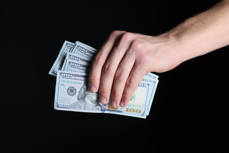 Man with dollar banknotes on black background, closeupの写真素材