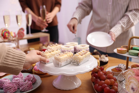 People taking different desserts from buffet table, closeupの写真素材
