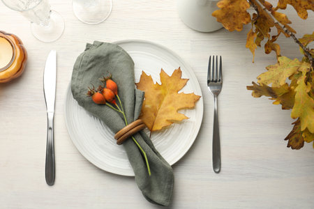 Beautiful table setting with autumn decor on white wooden background, flat layの写真素材